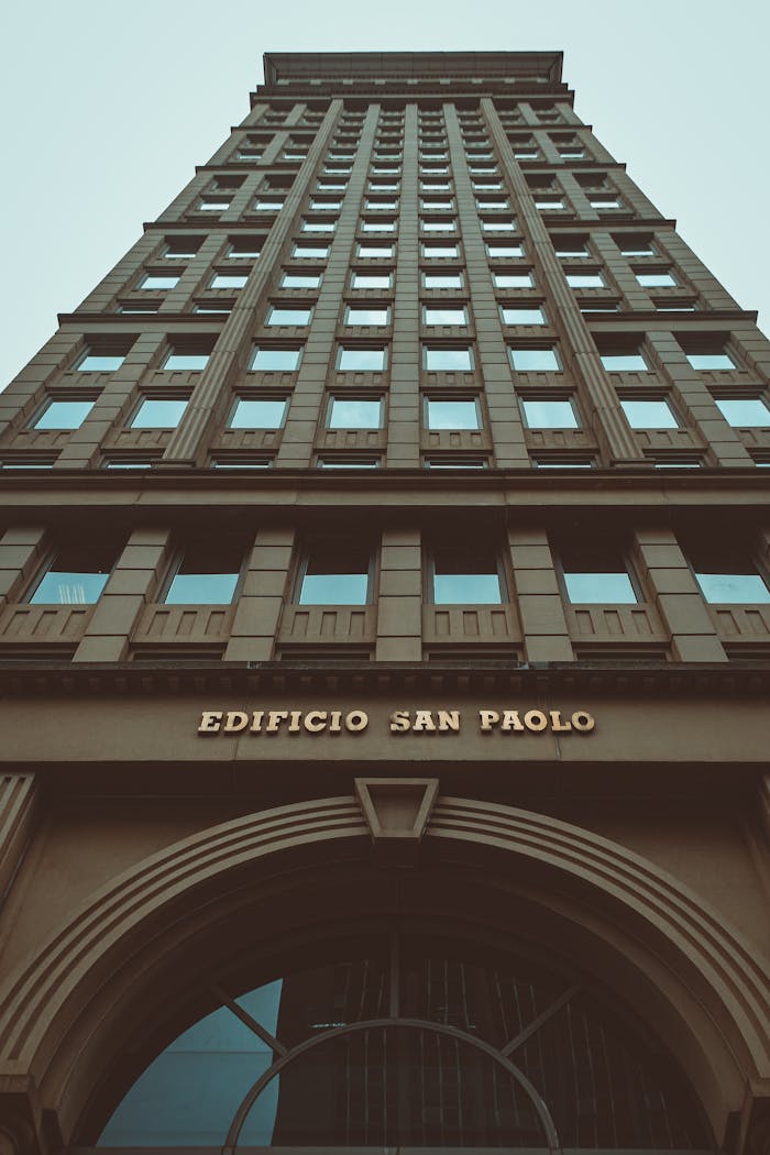 Low angle perspective exterior of modern residential building of brown color with square windows against blue sky